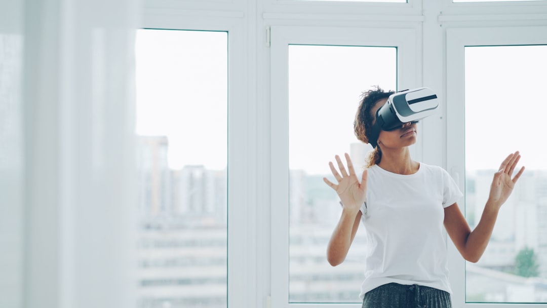 Woman using virtual reality headset indoors near window