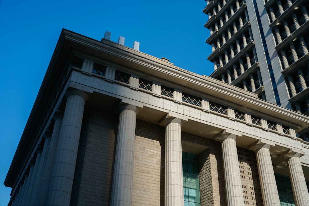 a tall building with columns and a clock on the front of it