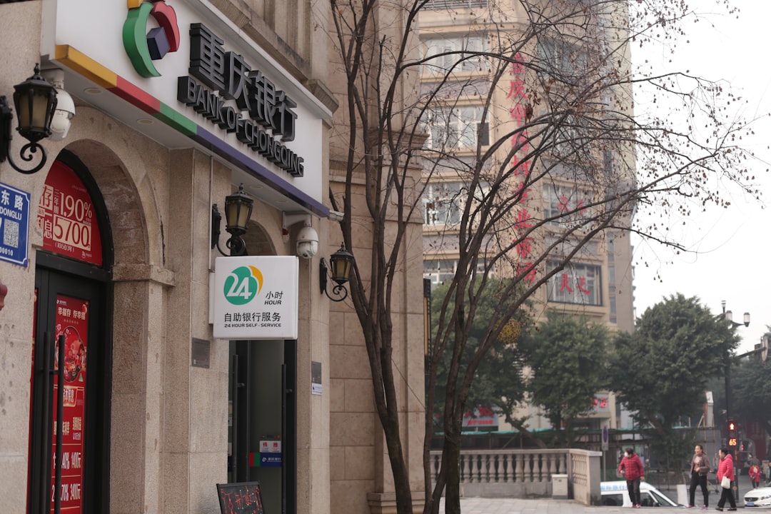 A bank building with signage and a bare tree.