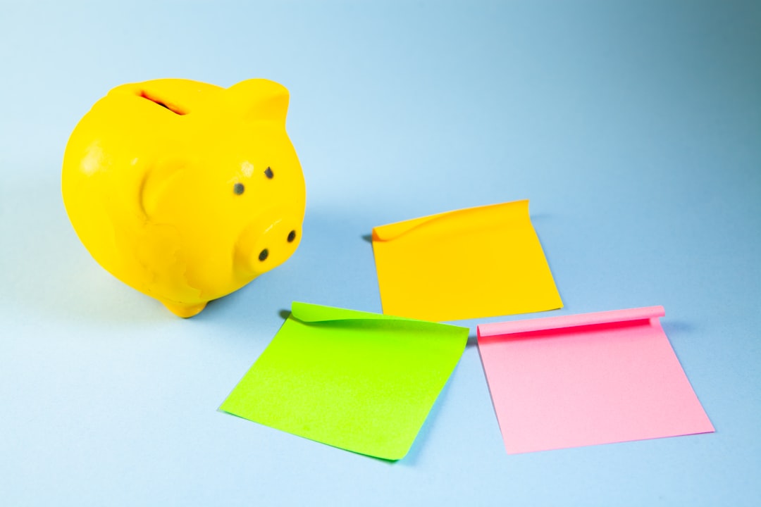 A yellow piggy bank with three colorful sticky notes.
