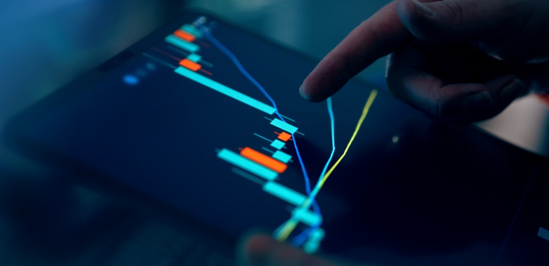 Fingers interacting with a stock market graph on a tablet.