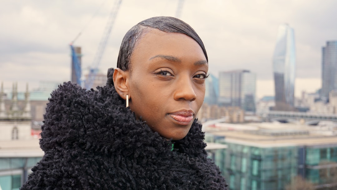 a woman in a black coat looking at the camera